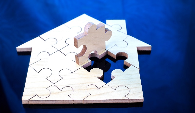 quebra cabeca forma casa e seta em ascensão