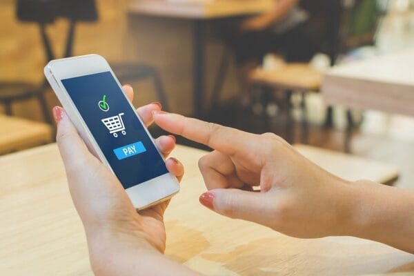 mão que compra em smarktphone: rede social de compras