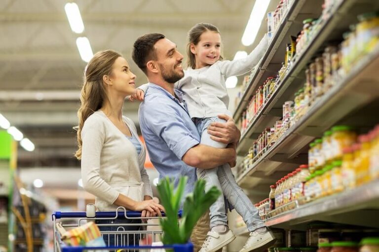 consumo mae, pai e filha escolhem produtos no mercado e empurram carrinho de compras