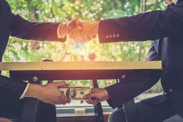 aperto de maos esconde por baixo entrega de dinheiro risco de calote e corrupção