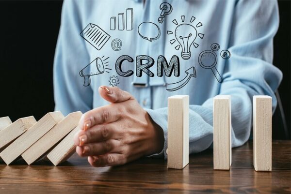 mão interrompe queda de blocos simulando uso de crm