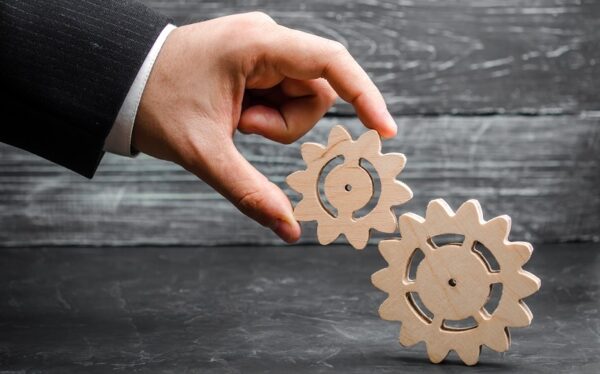 mão gira engrenagens para funcionarem juntas simbolizando engajamento