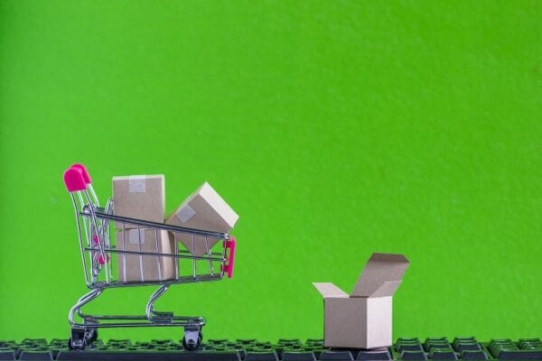 e-commerce e marketplace: carrinho de compras traz caixas e navega em cima de teclado