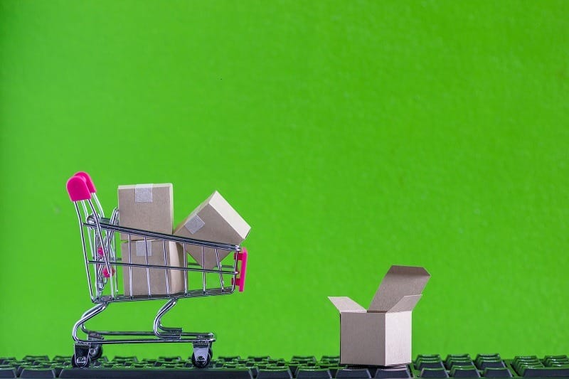 e-commerce e marketplace: carrinho de compras traz caixas e navega em cima de teclado