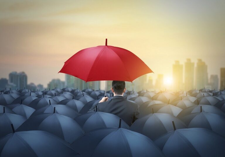 guarda-chuva vermelho em destaque entre guarda-chuvas mais baios todos iguais simboliza competência