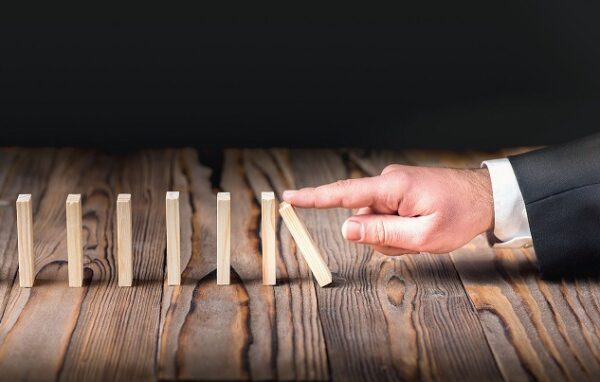 dedo pratica sabotagem ao empurrar pilha de dominós